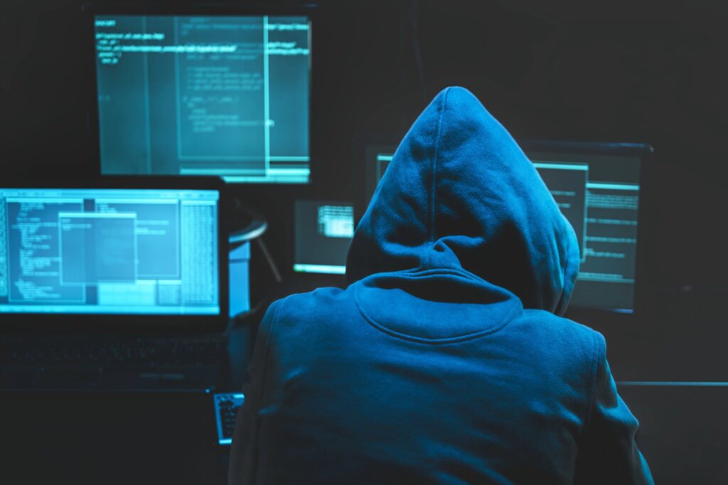 Children's data breach - picture of hooded hacker at computer screens