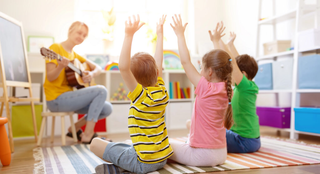 Children taking part in a music activity with their faces turned away from the camera